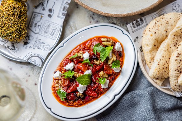 Pimentos marinados com harissa rosa, queijo feta de cabra batido e amêndoas za'atar.