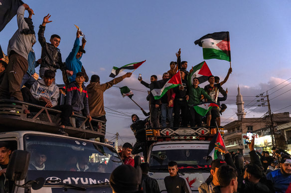 People waving flags celebrate 
while stuck in traffic leading up to the Lebanon-Syria Masnaa border crossing in Bar Elias, Lebanon.