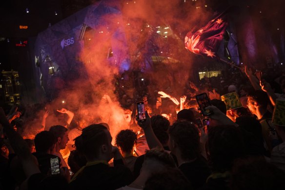 Fans let off flares at Fed Square before kickoff.