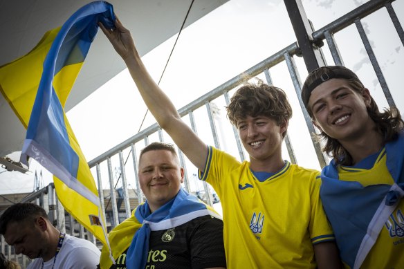 Ukranian tennis fan Peter Pelyshchuk and brothers Vitaly and Alex Davyd watch Oleksii Krutykh at the 2023 Australian Open.