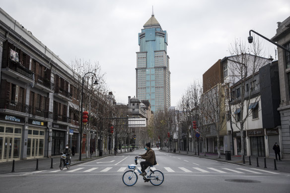 A man bicycles past an empty street on February 8, 2020 in Wuhan, Hubei province, China. 