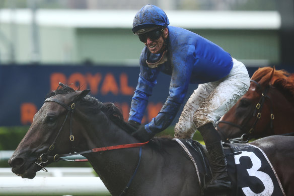 James McDonald grins through the mud after winning the Champagne Stakes on Broadsiding.