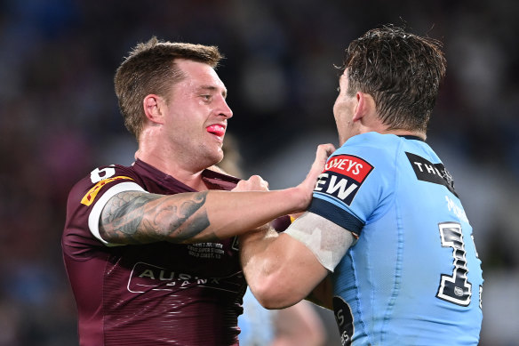 Cameron Munster of the Maroons and Angus Crichton of the Blues scuffle during game three.