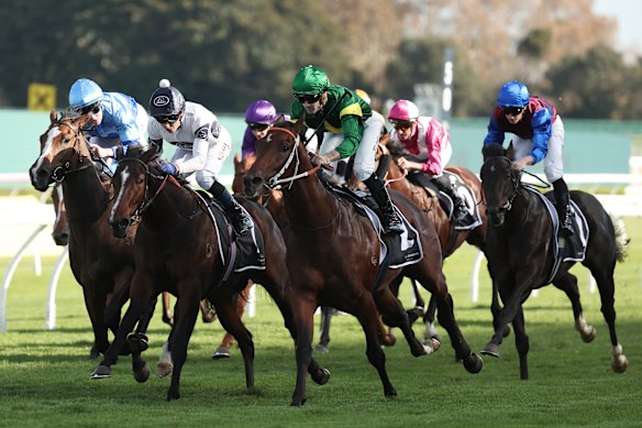 Tyler Schiller, in the green, wins on Nepotism in the Champagne Stakes.