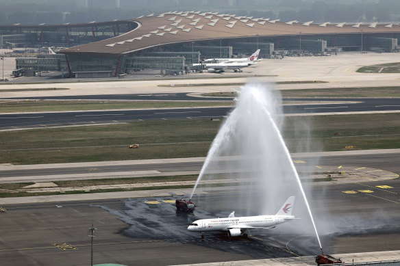 The plane is welcomed by water cannons at Beijing Capital International Airport.