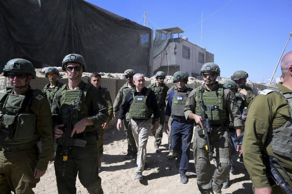 Prime Minister Benjamin Netanyahu (centre) walks with Israeli forces during a surprise visit to Rafah, Gaza, last month.