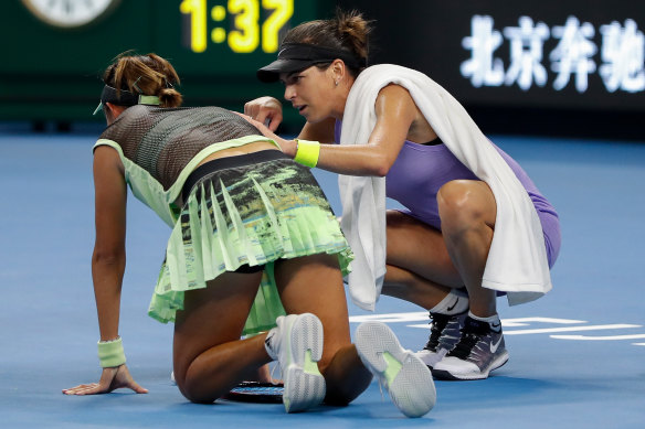 Ajla Tomljanovic assists injured rival Qiang Wang on court. 