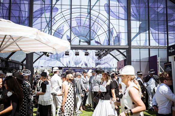 Racegoers in traditional Derby Day Black and White gather to watch Fashions on the Field
