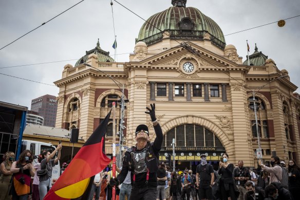 Protesters gather out the front of Flinders Street Station at an Invasion Day rally in 2021. 