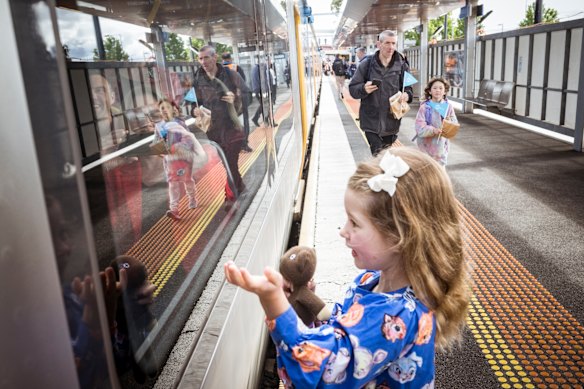 An excited young passenger at Sunbury station waves at those on the first service towards the Metro Tunnel on Sunday morning.