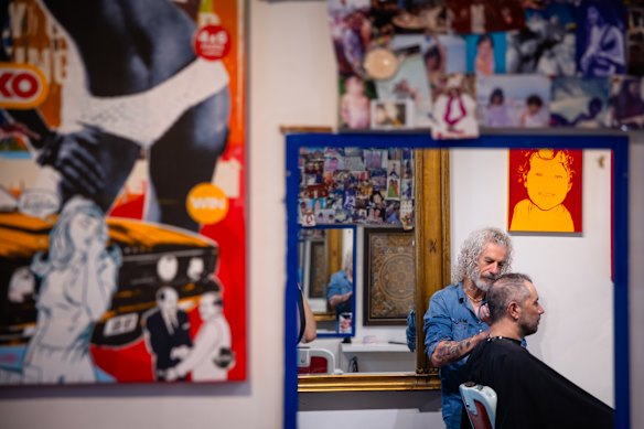 Matthew Clark, owner of The Barberia, does a regular customer’s hair during a busy Saturday afternoon.