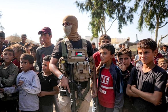 A masked fighter of the Ezzedine al-Qassam Brigades, the armed wing of the Hamas movement, stands guard in central Gaza as the Red Cross prepares to receive Israeli hostages on Monday.