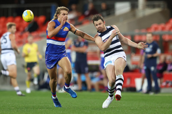 Patrick Dangerfield gets a kick away for the Cats as Bailey Smith moves in for the Bulldogs.