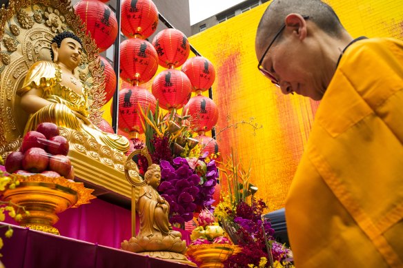 A monk prays at a Buddhist shrine erected in a square in Melbourne’s Chinatown.