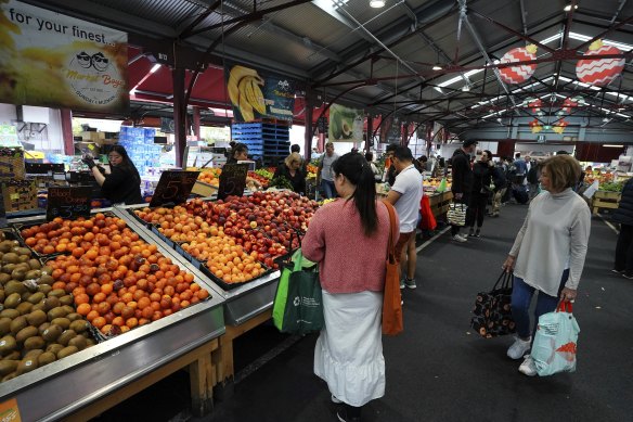 People shop for fruit and vegetables under the simple but effective historic sheds at the Queen Vic Market. 
