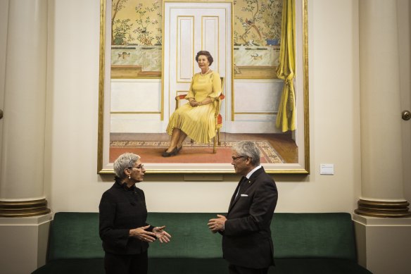 Governor of Victoria Linda Dessau and husband Anthony Howard in front of a portrait of the Queen by Brian Dunlop.