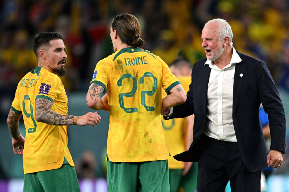 Graham Arnold celebrates with Jamie Maclaren and Jackson Irvine.