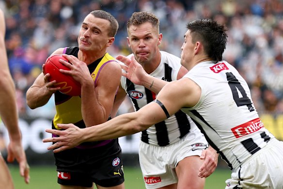 Richmond’s Taj Hotton is tackled by Pies Brayden Maynard and Dan Houston.