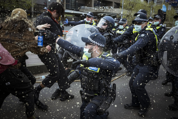 Police use pepper spray on protesters.