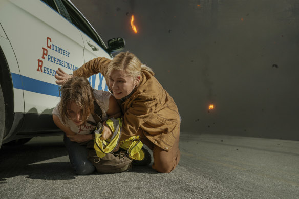 Photographers Jessie (Cailee Spaeney) and Lee (Kirsten Dunst) shelter from attack in a scene from Alex Garland’s Civil War.