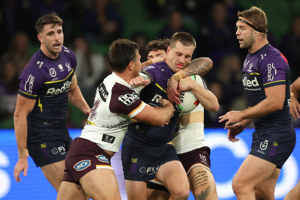 Cameron Munster is tackled by Brisbane players.