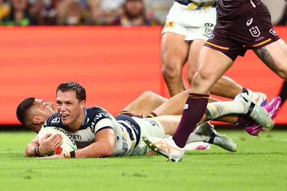 Scott Drinkwater of the Cowboys scores a try against the Broncos.