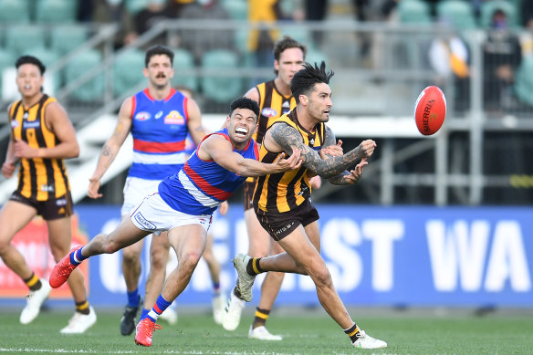 Hawthorn’s Chad Wingard gets the ball away under pressure from Bulldog Jason Johannisen.