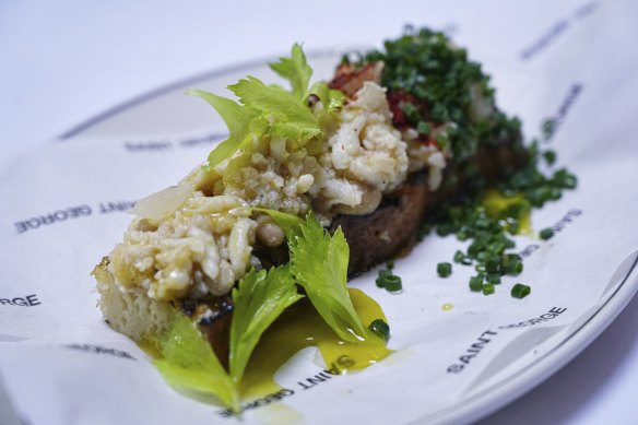 Spanner crab toast topped with Aleppo pepper and celery leaves.