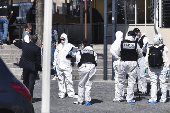 Police officers investigate on Saturday after a Sudanese man wielding a knife attacked residents of Romans-sur-Isere who were out shopping in the town under lockdown.
