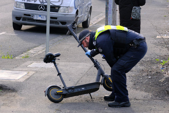Police officers inspect an e-scooter in Brunswick on Monday.