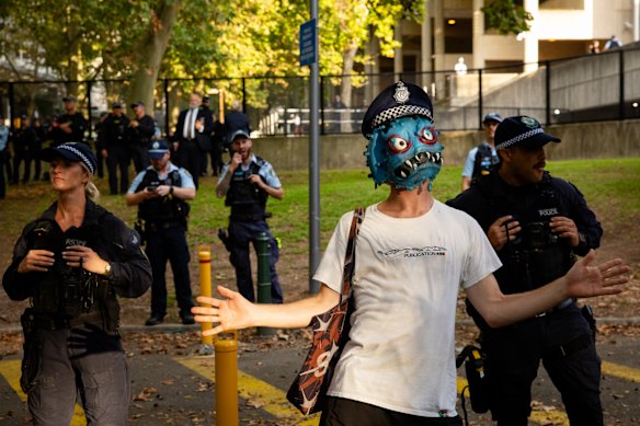A protester taunts officers as protesters gather near Surry Hills police station. 