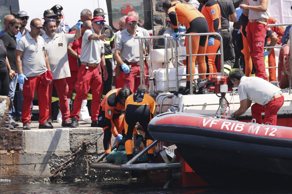Italian divers are pictured on Friday after recovering the body of one the victims of the shipwreck.