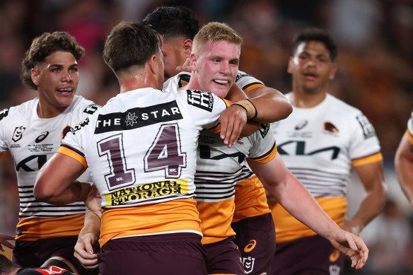 Thomas Flegler of the Broncos celebrates with teammates after scoring a try.