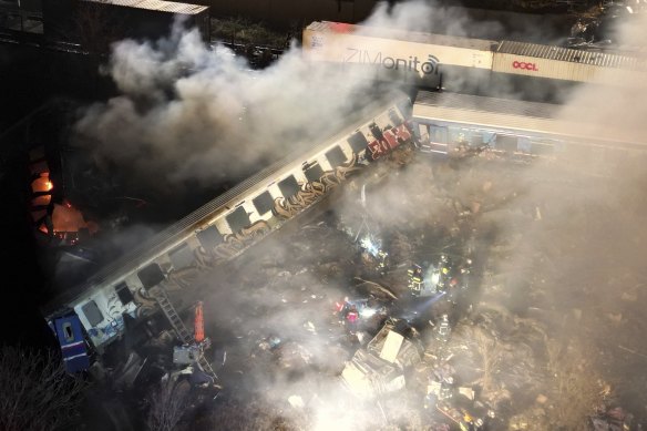 Smoke rises from trains as firefighters and rescuers operate after a collision near Larissa city, Greece, early on Wednesday.