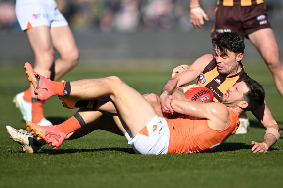 Toby Greene of the Giants is tackled by Conor Nash of the Hawks.