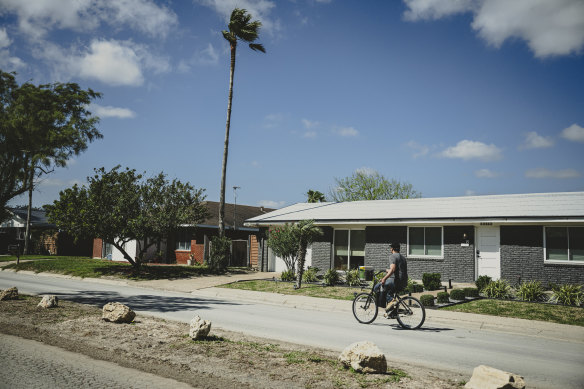 A man rides a bike down Memes Street, in the proposed city of Starbase, Texas.