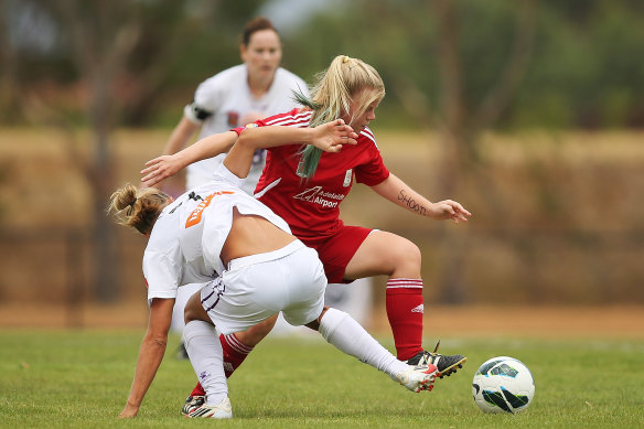 Jess Waterhouse (right) wins the ball for Adelaide United in the W-League.