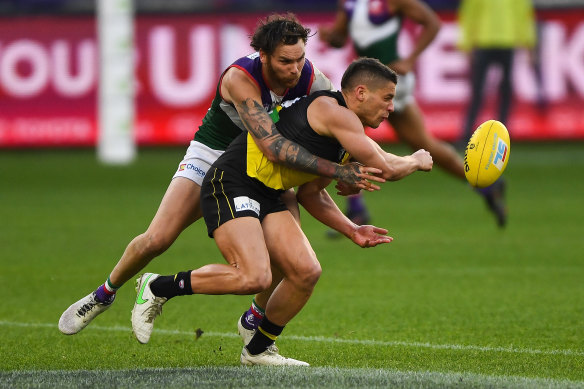 Dion Prestia gets a handball away under pressure from Nathan Wilson.