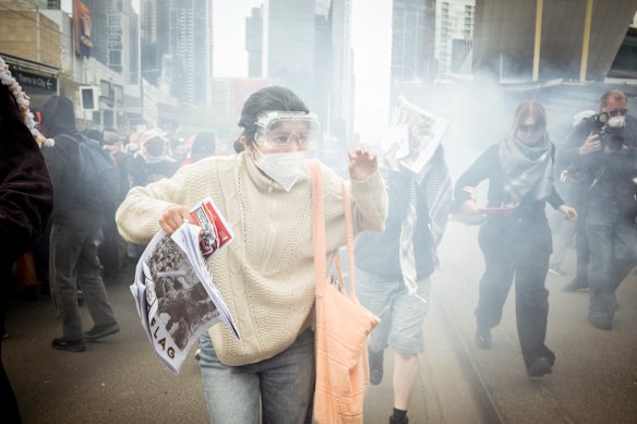 Protesters flee after police deployed tear gas on the crowd.