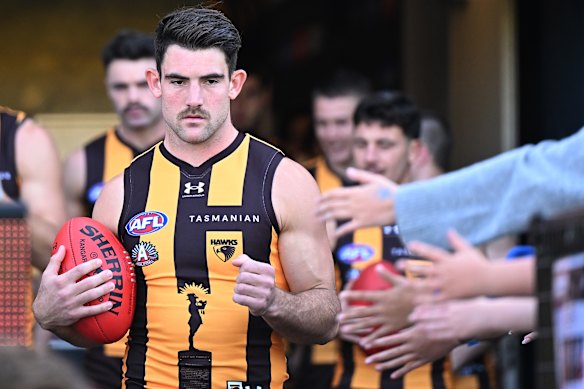 Hawthorn co-captain Jai Newcombe, with the Tasmania logo on his guernsey, leads his side onto UTAS Stadium on Anzac Day.