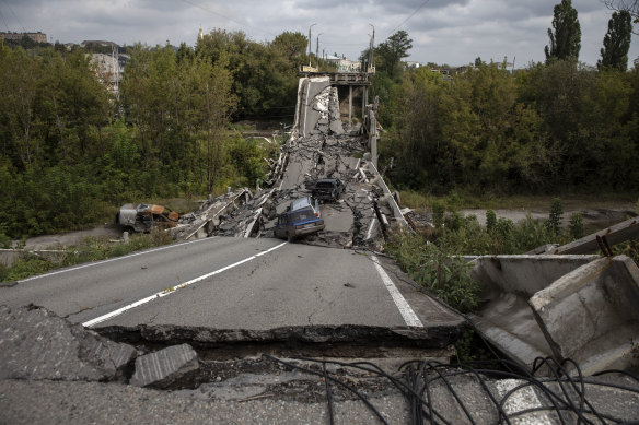 Ukrayna'nın Kupiansk kentinde 16 Eylül'de Ukrayna'nın Rus askerlerini geri zorladığı hasarlı bir köprünün üzerinde ve çevresinde araçlar görülüyor.