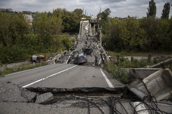 Vehicles are seen on and around a damaged bridge in Kupiansk, Ukraine, on September 16, where Ukraine forced back Russian soldiers.