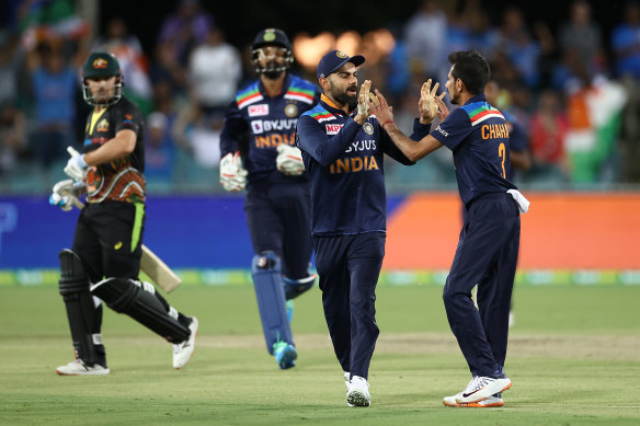  Australian captain Aaron Finch trudges off as Virat Kohli congratulates Yuzvendra Chahal for the first of his three wickets.