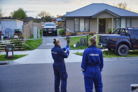 Police outside the scene where two men, a woman and a teenage boy were found dead.