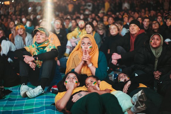 Fans react to the growing tension of the of the match, at Darling Harbour in Tumbalong Park.