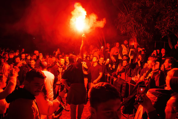 A soccer fan lets off a flare at Melbourne’s Federation Square during the Socceroos’ World Cup match.
