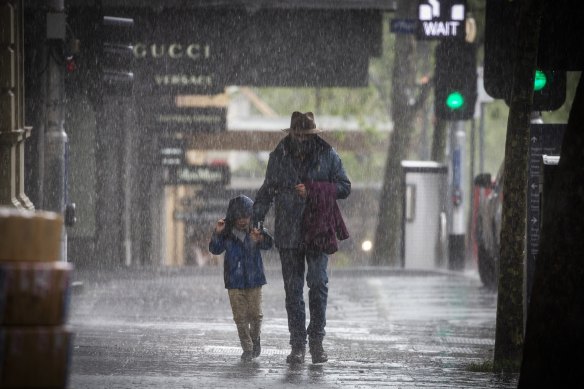 Pedestrians on Melbourne’s Collins Street battle the rain on Friday morning.