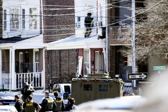 Police surround a home in Trenton, New Jersey, where the gunman was believed to have barricaded himself before later escaping.