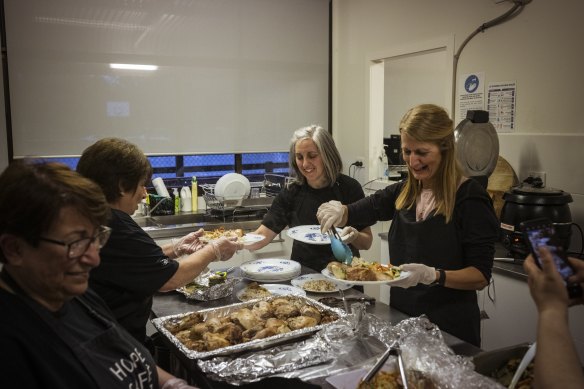 Volunteers Marie, Irene, Pilomina and Beverly prepare meals for guests.