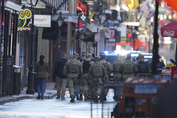 Military personnel walk down Bourbon Street on Thursday in New Orleans.